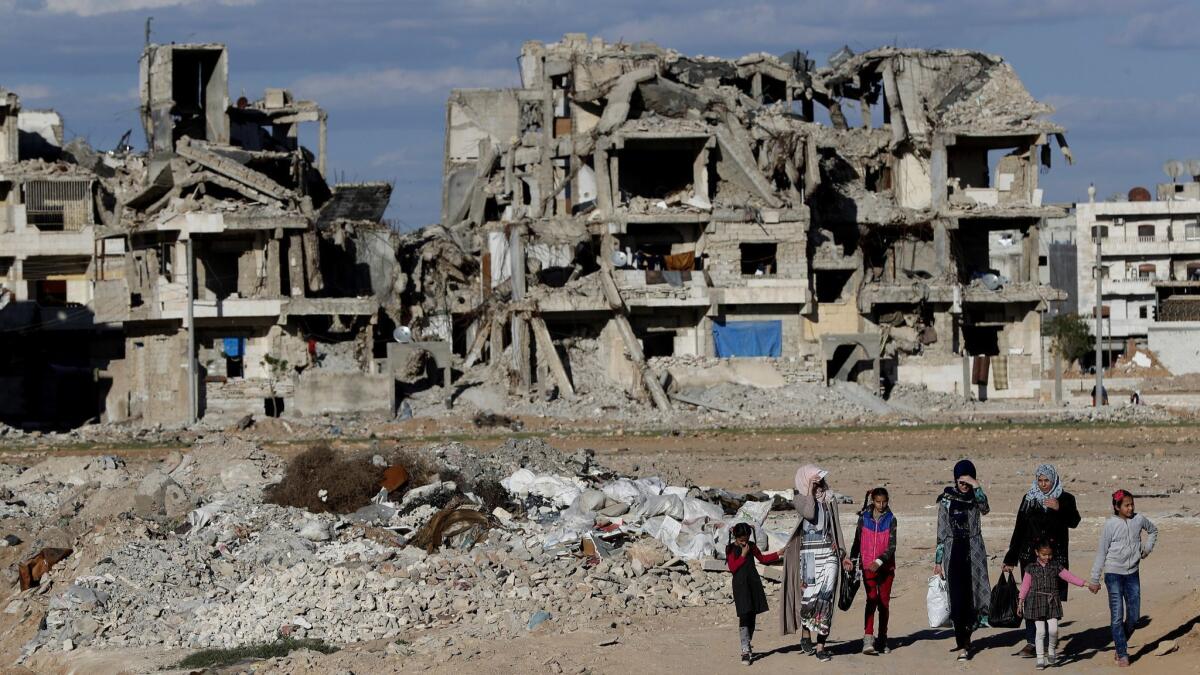 Syrians walk among the devastation in Manbij after a battle between the U.S.-backed Syrian Democratic Forces and Islamic State militants in March 2018.