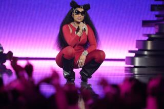 Nicki Minaj squats while performing onstage