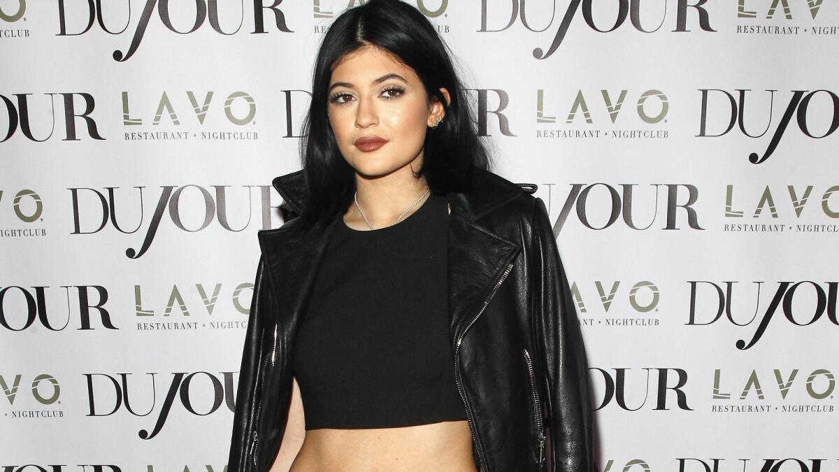 Kylie Jenner works her controversial pout at an event in August. The 17-year-old said she's "bored" with all the talk about her lips.