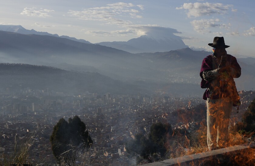 Un líder espiritual andino toma una foto con un teléfono inteligente durante un ritual de Año Nuevo 