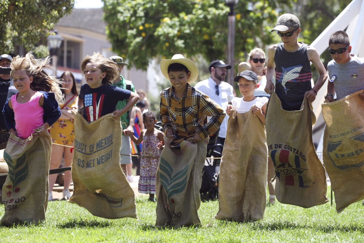 Children compete in a sack race during the Old Town 1800's July Fourth celebration at Old Town San Diego State Historic Park.