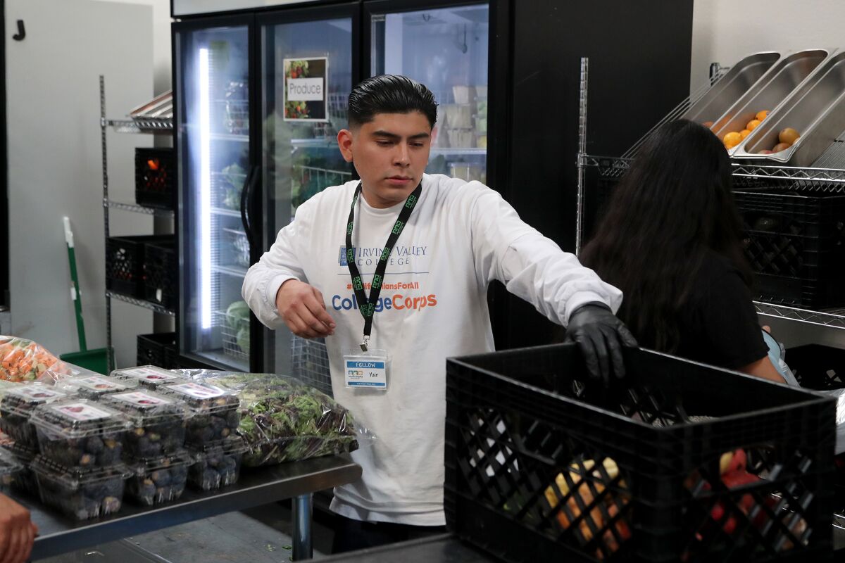 Yair Rivera, 21, a freshman at Irvine Valley College, restocks fresh produce at South County Outreach in Irvine on Thursday.