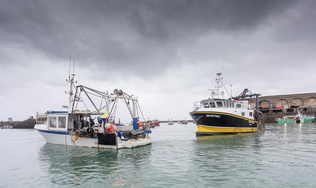 Two fishing boats under a cloudy sky