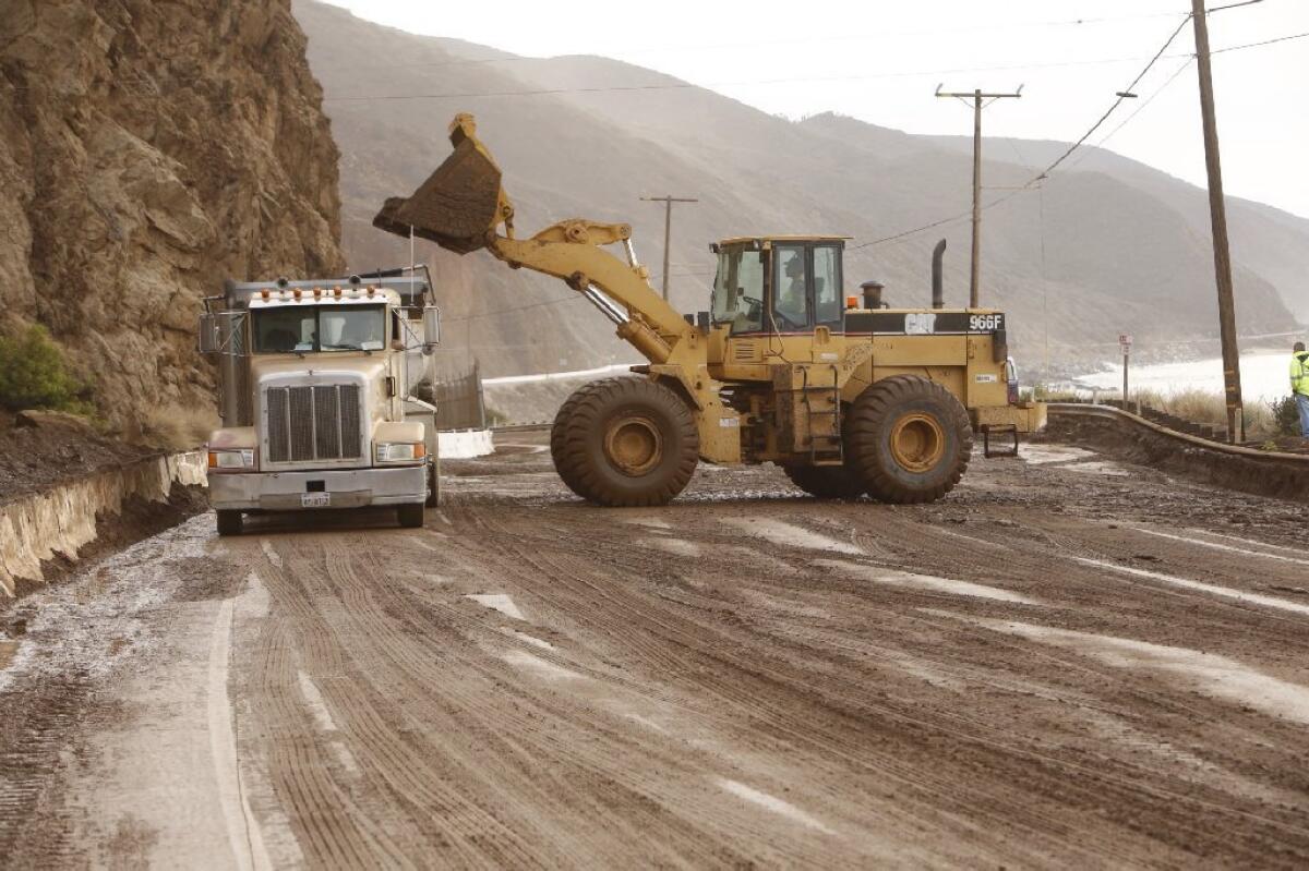 Work crews remove mud and debris earlier from a landslide that closed Pacific Coast Highway between Las Posas and Yerba Buena roads. The highway reopened on Friday.