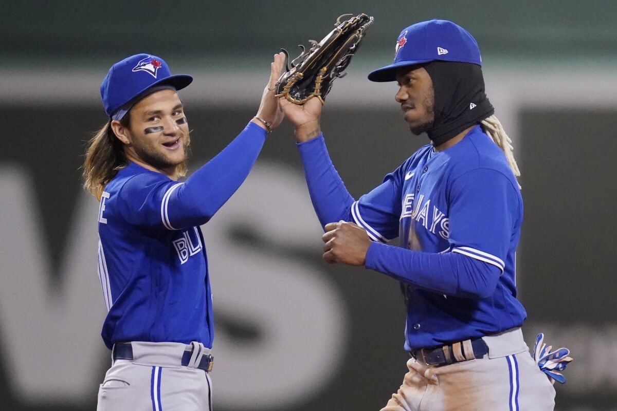 Toronto Blue Jays' Raimel Tapia, right, celebrates with Bo Bichette after the Blue Jays defeated the Boston Red Sox 6-1 during a baseball game, Wednesday, April 20, 2022, at Fenway Park in Boston. (AP Photo/Charles Krupa)