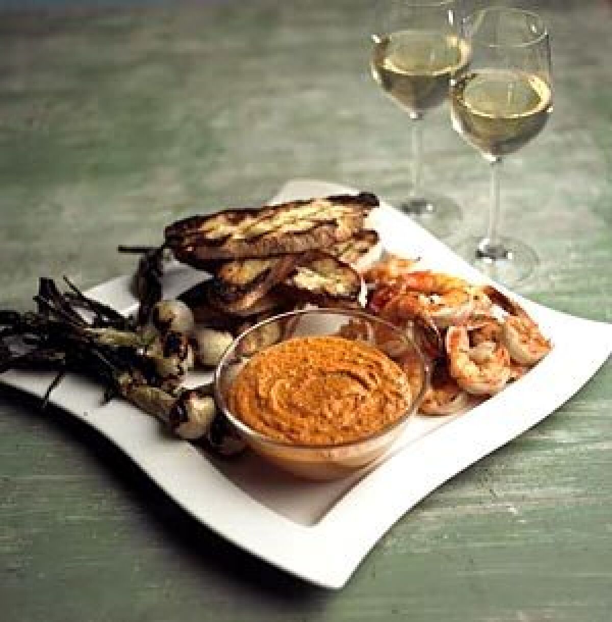 COMPLEX: Roasted red pepper romesco brings out the delicate flavors of grilled shrimp and sweet spring onions.