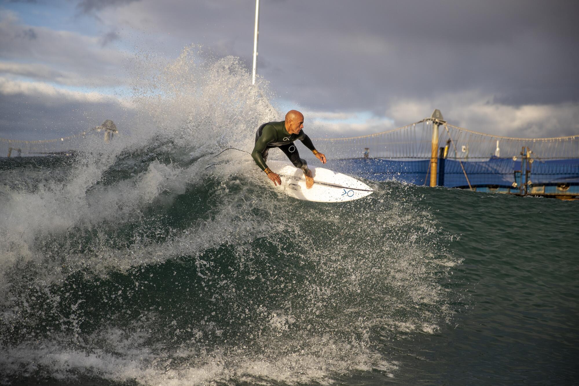 Kelly Slater rides a wave on his surfboard