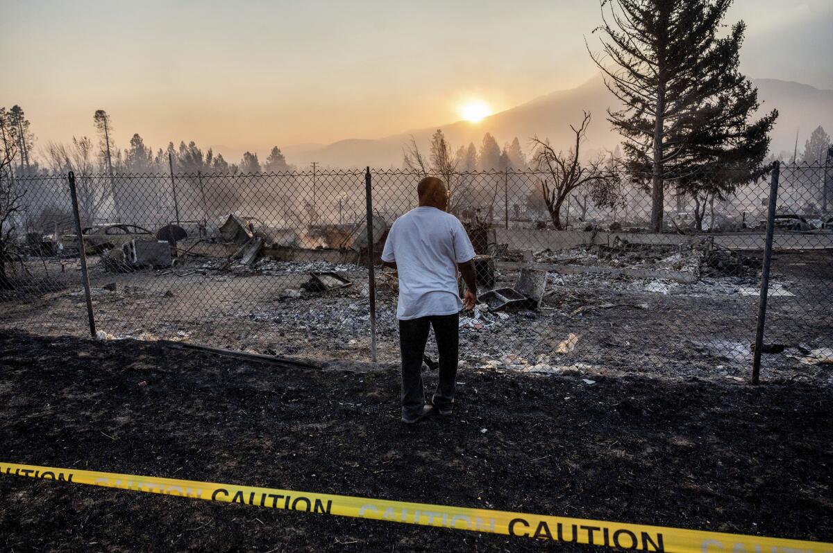 A man looks at burned remains of a home