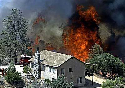 A wall of flame threatens a ranch house Thursday in the Tweedy Lake area of the Antelope Valley. Firefighers managed to save the structure. Fires threatened residences in the rural Three Points, Tweedy Lake and Lake Hughes areas.