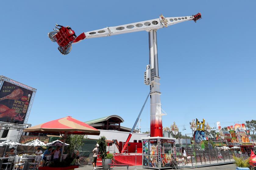 Riders get flipped upside down high above the ground as a new ride called Titan takes them on a spinning trip on long metal arms, at the Orange County Fair in Costa Mesa on Saturday, July 20, 2019. This is one of four new rides at the fair.