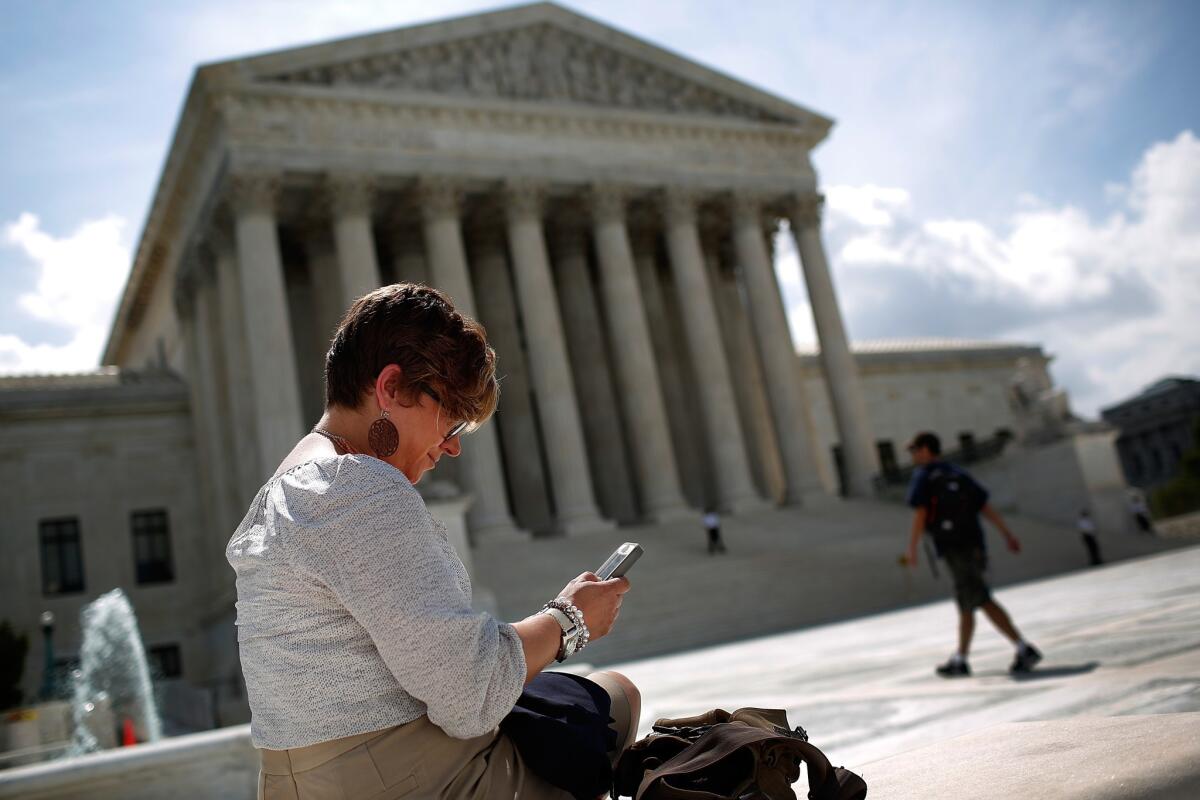 Kirsten Luna from Holland, Michigan, uses her smartphone outside the U.S. Supreme Court after a major ruling on cellphone privacy by the court in Washington, D.C.