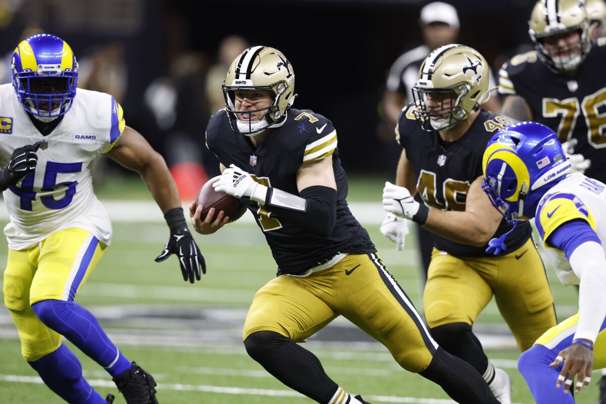 The Saints' Taysom Hill (7) runs the ball against the Rams in the first half.