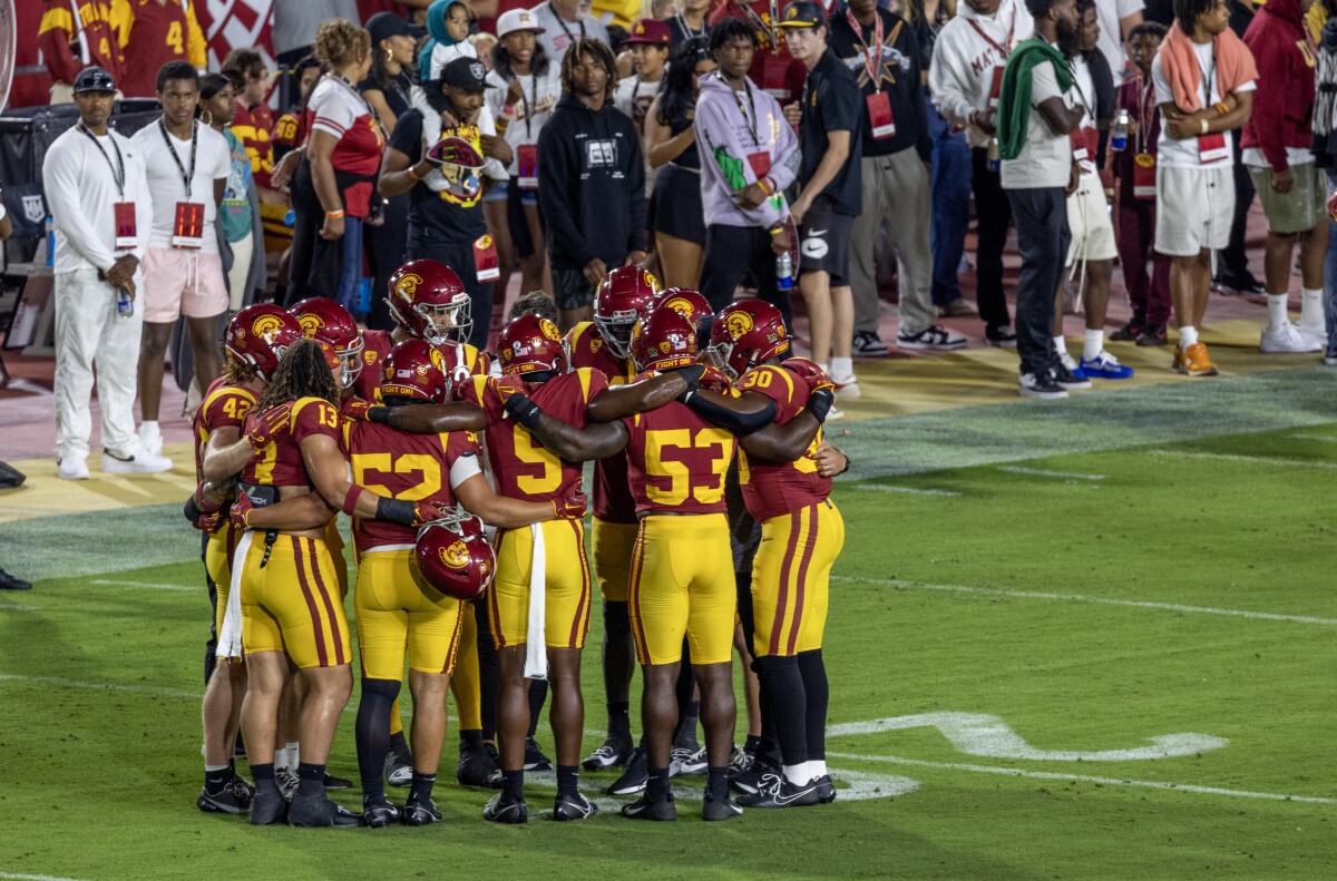 USC defensive players huddle on the field before playing Arizona at Coliseum on Oct. 7.