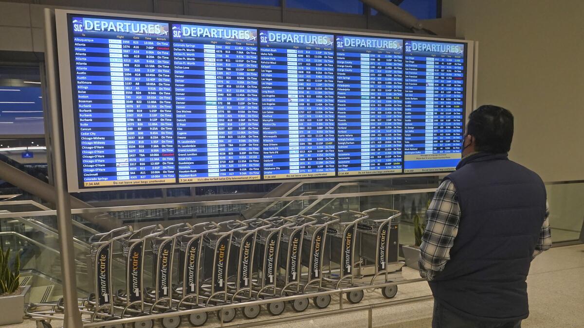 Un hombre observa las pantallas de salidas de vuelos en el Aeropuerto Internacional de Salt Lake City.