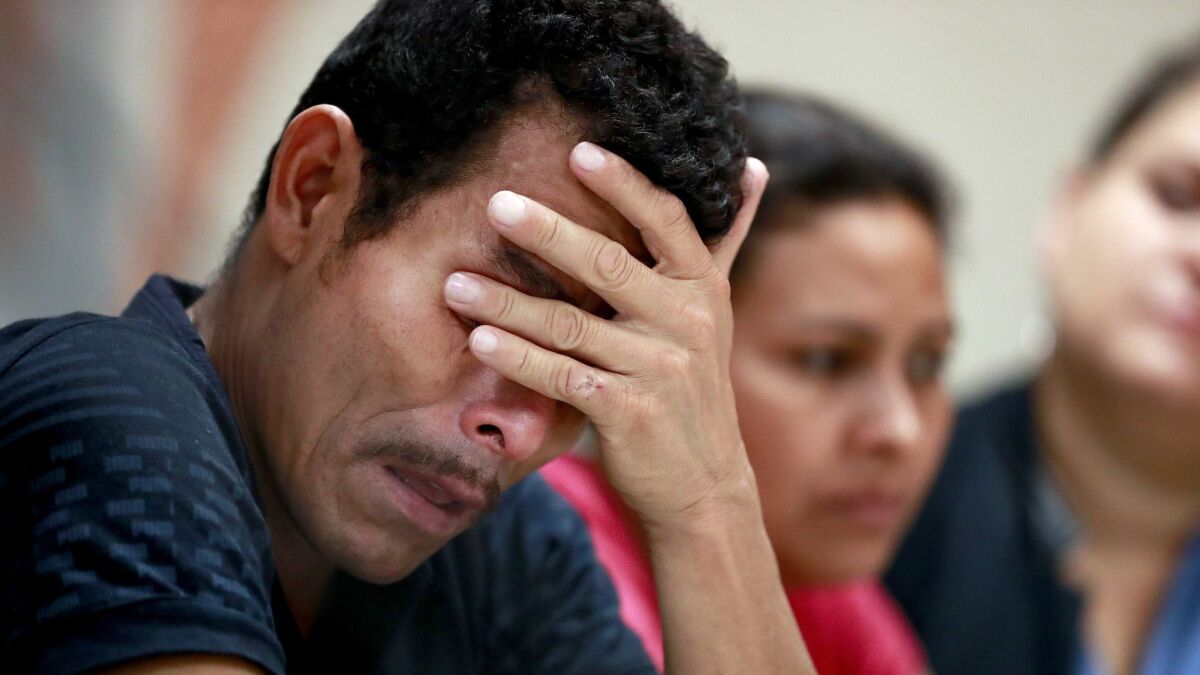 Melvin and Iris, both from Honduras, listen as they hear other immigrants tell of their separation from their children at the border during a news conference at the Annunciation House, Monday, June 25, 2018, in El Paso, Texas.
