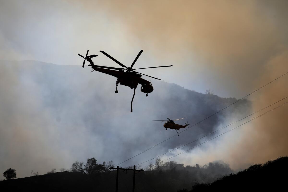 Two helicopters surrounded by smoke.