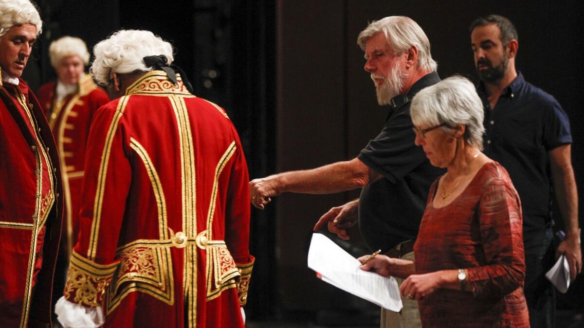 San Diego Opera's longest-serving employees and spouses, John David Peters and Mary Yankee Peters, at right, discuss scene changes during a rehearsal of "The Marriage of Figaro" earlier this month. They're retiring together when the opera closes on Oct. 28.