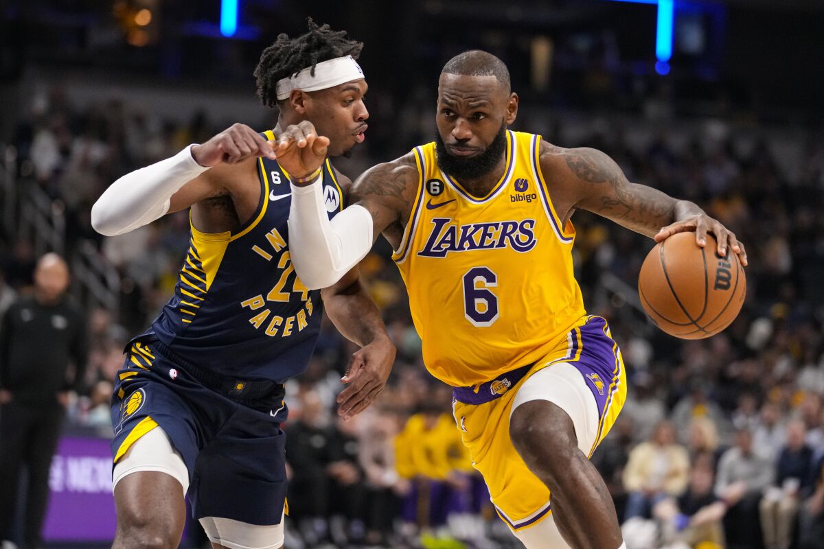 Lakers star LeBron James drives on Indiana Pacers guard Buddy Hield during a game on Feb. 2.