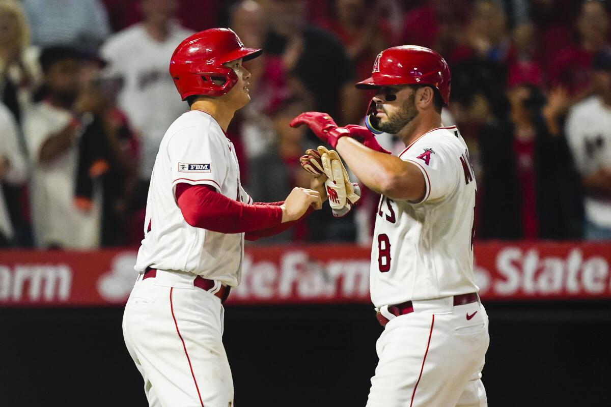 The Angels' Mike Moustakas celebrates with Shohei Ohtani after hitting a three-run home run to put the Angels ahead.