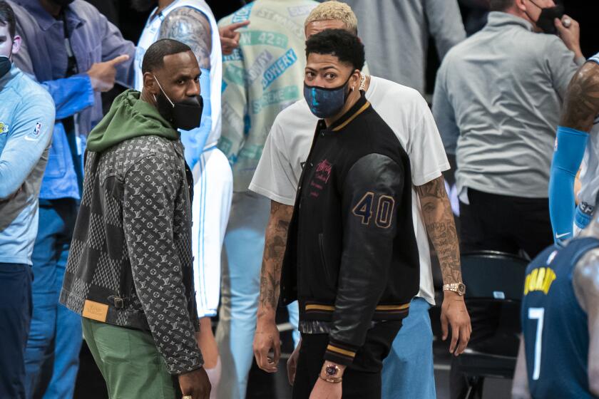 Los Angeles Lakers forward LeBron James and forward Anthony Davis look on during a time out in the second half of an NBA basketball game against the Brooklyn Nets, Saturday, April 10, 2021, in New York. (AP Photo/Corey Sipkin)
