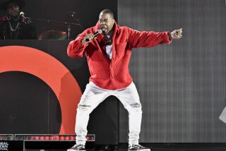 tour of c Busta Rhymes wears a red jacket and white pants while performing onstage
