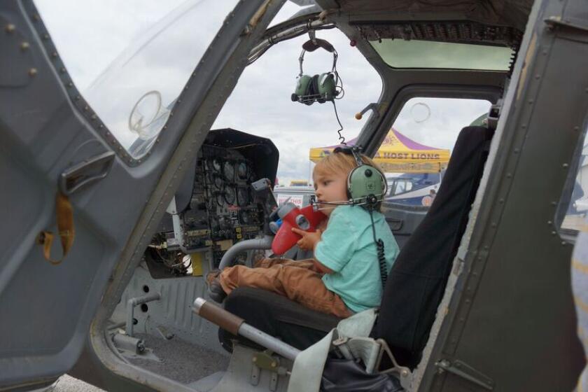 A small child sits in the cockpit of an aircraft during Airport Day at Fullerton Airport.