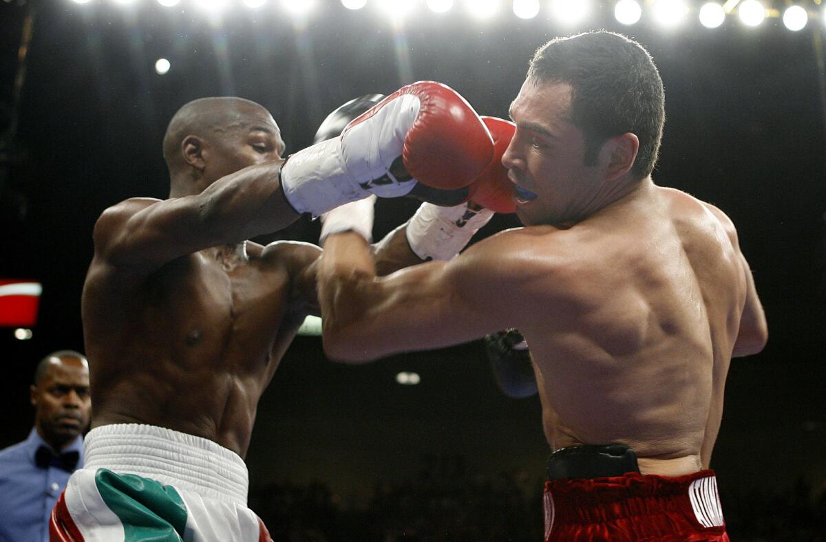 Floyd Mayweather Jr., left, punches Oscar De La Hoya.