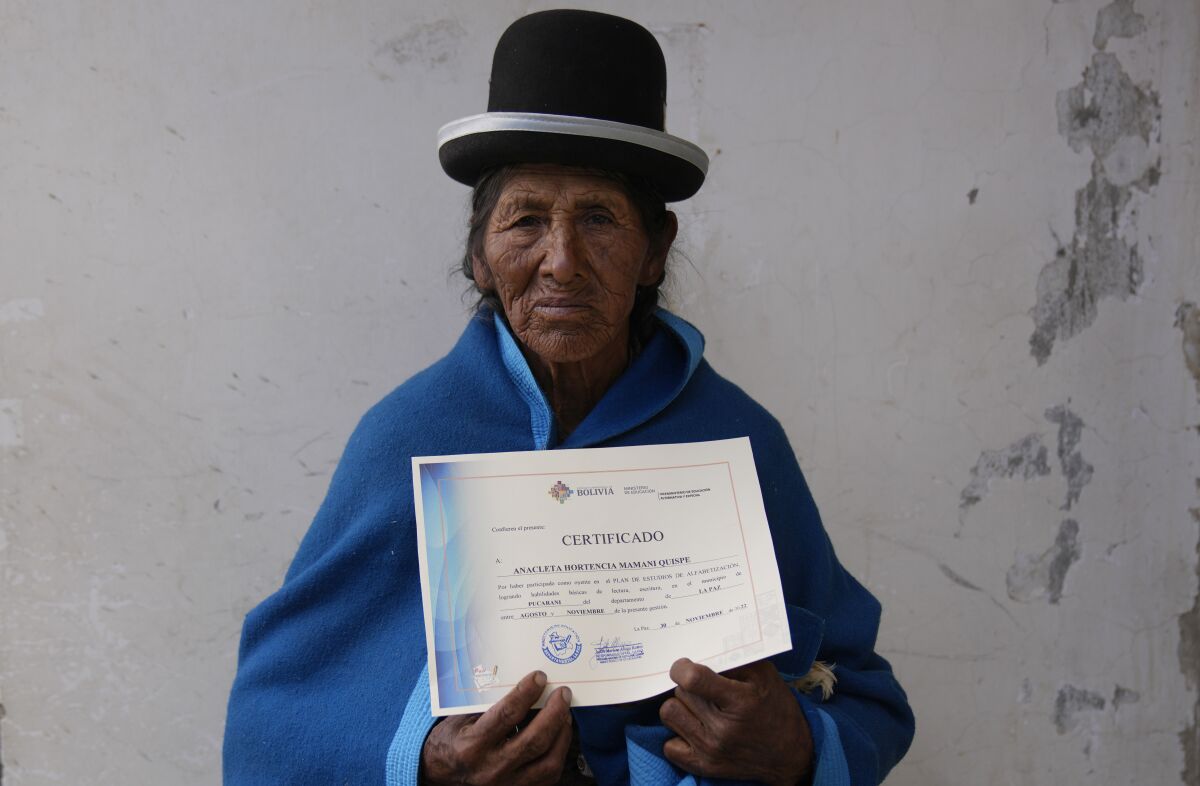 Indigenous woman from Bolivia poses with literacy certificate