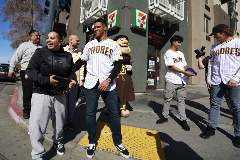 San Diego CA - February 3: San Diego Padres' Juan Soto tosses the Dodgers hat Jessica Rubio was wearing to Ethan Salas and gave her his Padres hat in Little Italy as players spread throughout the county making unannounced stops for the Padres Community Tour on Friday, February 3, 2023. (K.C. Alfred / The San Diego Union-Tribune)