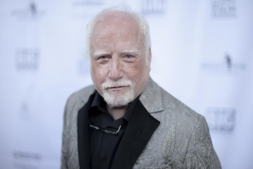 Richard Dreyfuss slighly smiles and leans forward at a premiere