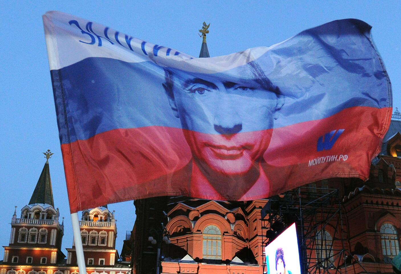 A Russian flag featuring Prime Minister Vladimir Putin flies above his supporters at a square just outside the Kremlin in Moscow as they celebrate Putin's election on March 5, 2012. Putin regained the presidency after four years as prime minister.