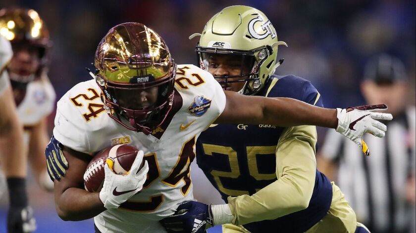 Mohamed Ibrahim (24) of the Minnesota Golden Gophers battles for yards during a first half run while being tackled by Tariq Carpenter (29) of the Georgia Tech Yellow Jackets during the Quick Lane Bowl at Ford Field in Detroit, Michigan.