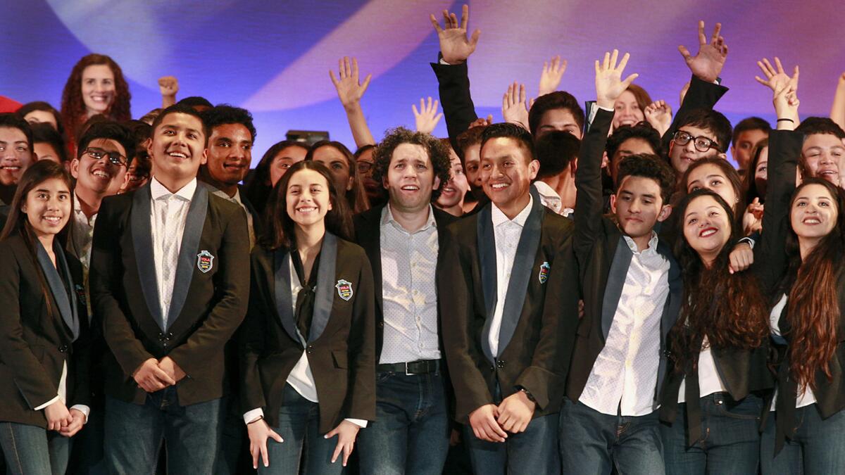 Gustavo Dudamel and Youth Orchestra Los Angeles celebrate onstage after a concert in 2016.