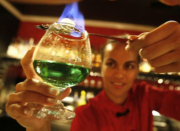 Bartender Linda Mani serves up a "Bohemian style" absinthe at the Bar Noir at the Hotel Maison 140 in Beverly Hills. The bar serves up absinthe cocktails in an elaborate ritual from 5 to 7 p.m. called the Green Hour. The storied green drink that was once banned in the U.S. is rich with rumors of hallucinogenic properties and a distinctive sweet flavor of licorice.