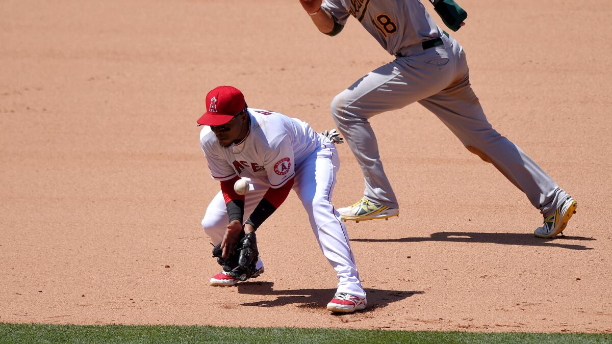 Angels shortstop Erick Aybar commits an error on a ball hit by Oakland's Brett Lawrie as Ben Zobrist runs to third base in the seventh inning Sunday in Anaheim.