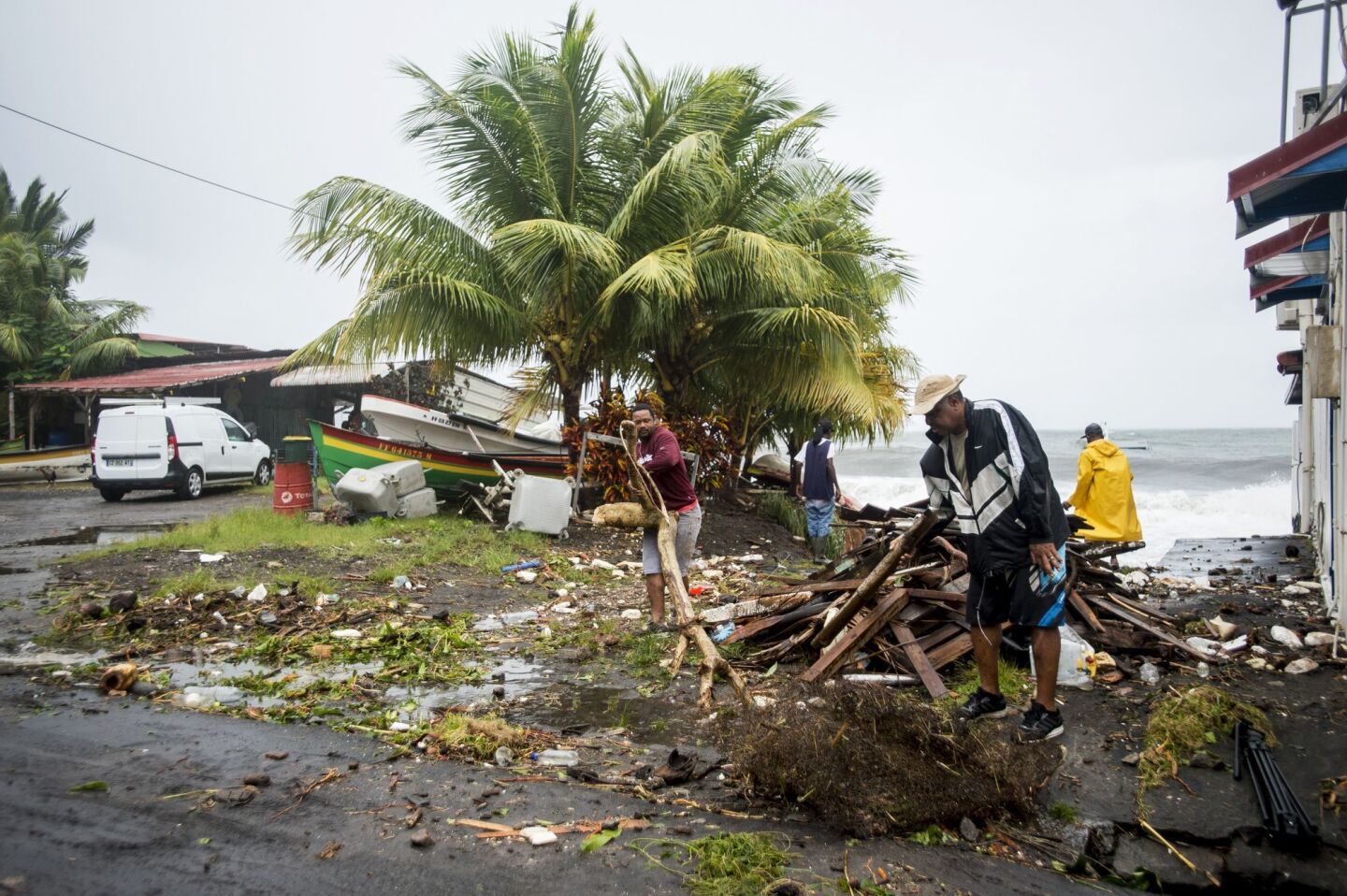 People clear debris in Saint-Pierre, on the French Caribbean island of Martinique, after it was hit by Hurricane Maria.