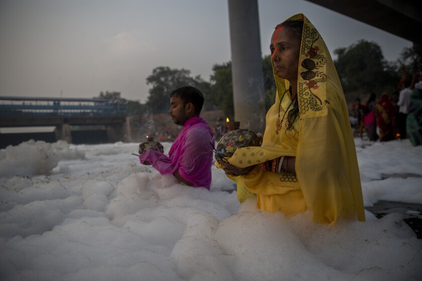 Hindúes se bañan en río sagrado cubierto de espuma tóxica