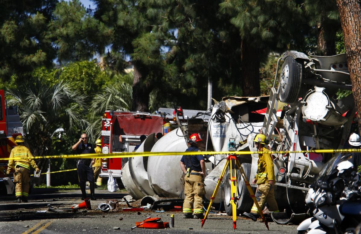 Firefighters and police officers work at the scene where a cement truck overturned May 9 on the 1000 block of Loma Vista Drive in Beverly Hills.
