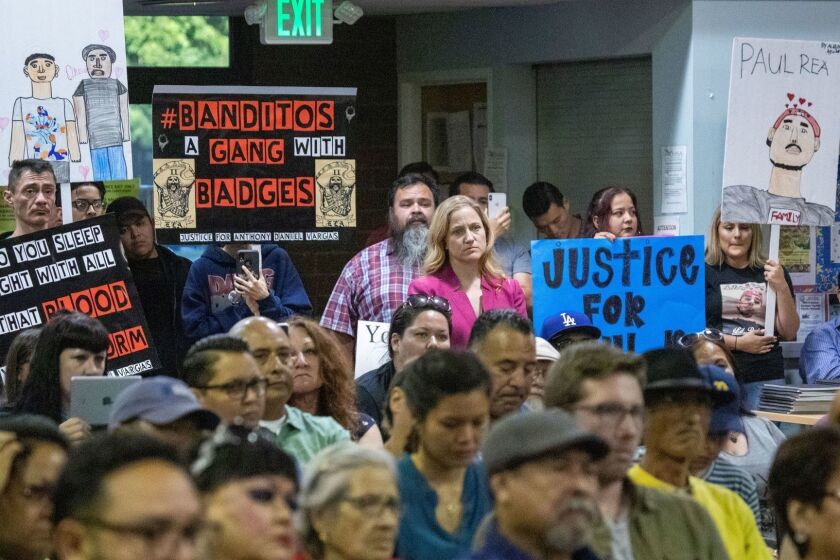 LOS ANGELES, CALIF. -- THURSDAY, JULY 11, 2019: East Los Angeles residents, activists and concerned citizens hold signs in protest while attending the Sheriff Civilian Oversight Commission?s town hall focused specifically on the East Los Angeles Station of the LA County Sheriff's Department. Community members discuss the allegations of secret societies of deputies with matching tattoos, and how the FBI is investigating the Banditos, an inked group of deputies at the ELA station. Photos taken at the Los Angeles County East LA Community Service Center in East Los Angeles, Calif., on July 11, 2019. (Allen J. Schaben / Los Angeles Times)