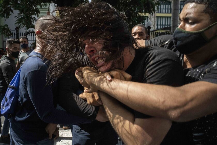 Plainclothes police detain an anti-government protester during a protest in Havana, Cuba, Sunday, July 11, 2021. Hundreds of demonstrators went out to the streets in several cities in Cuba to protest against ongoing food shortages and high prices of foodstuffs, amid the new coronavirus crisis. (AP Photo/Ramon Espinosa)