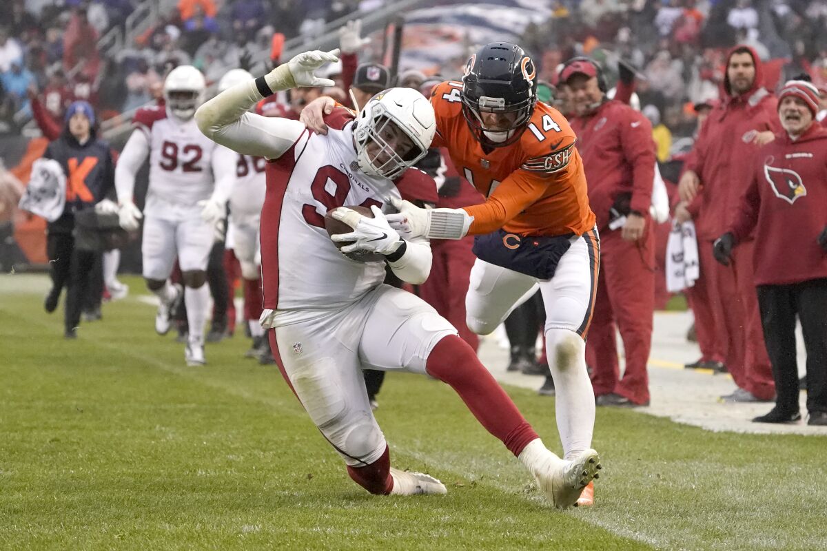 Chicago Bears quarterback Andy Dalton (14) tackles Arizona Cardinals defensive end Zach Allen after Allen intercepted a Dalton pass during the second half of an NFL football game Sunday, Dec. 5, 2021, in Chicago. The Cardinals won 33-22. (AP Photo/David Banks)