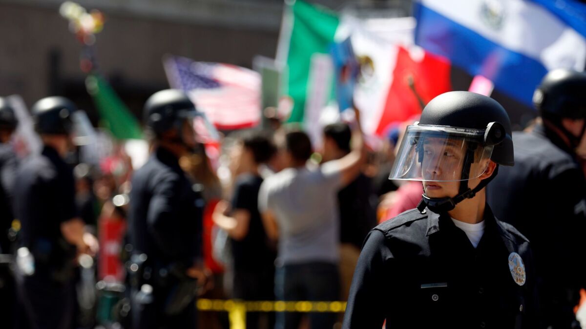 LAPD officers form a wall between pro- and anti-Trump protesters at 1st and Spring streets in downtown Los Angeles at the conclusion of separate May Day marches and rallies on Monday.