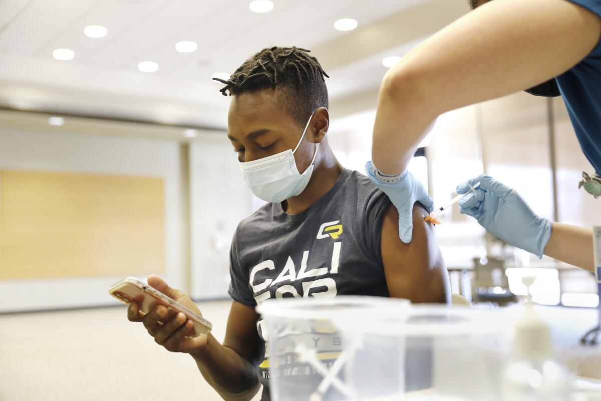 A teenager receives a COVID-19 vaccine.