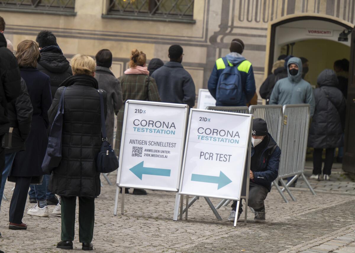 People line up at a COVID-19 testing center in the courtyard of the Residenz, in Munich, Germany, Wednesday, Nov. 24, 2021. (Peter Kneffel/dpa via AP)