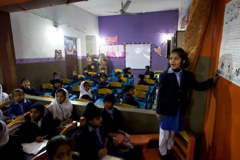 In this Friday, Jan. 19, 2018 photo, a Pakistani student shares information with her classmates regarding awareness about rape and kidnap attempts at a school in Kasur, Pakistan. A child protection committee has launched a program in schools warning children against going with strangers following the brutal rape of Zainab Ansari, whose body was left in a garbage dump earlier this month, which has roiled Conservative Pakistan and revealed a sexual predator who has raped and killed at least 11 girls in Zainab's hometown of Kasur. He is still at large. (AP Photo/B.K. Bangash)