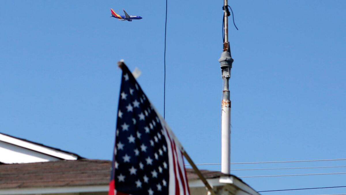 A Southwest Airlines jet passes over Mario Tabernig's home in Huntington Beach on Thursday.