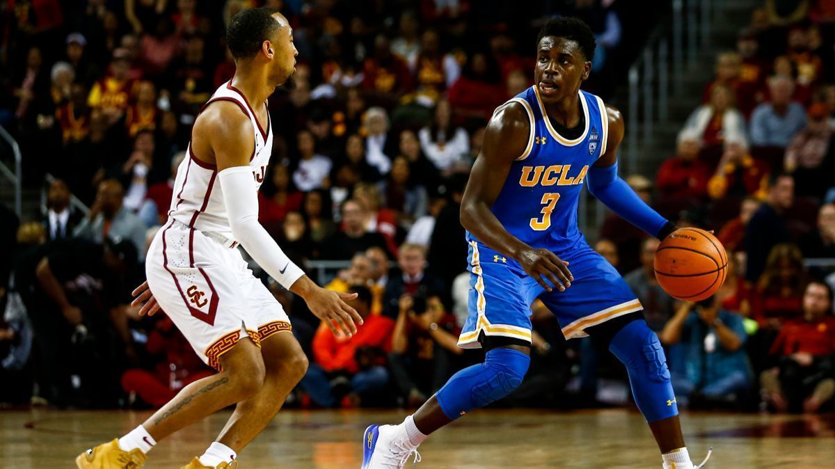 USC guard Jordan McLaughlin, left, and UCLA guard Aaron Holiday compete at the Galen Center on Saturday.