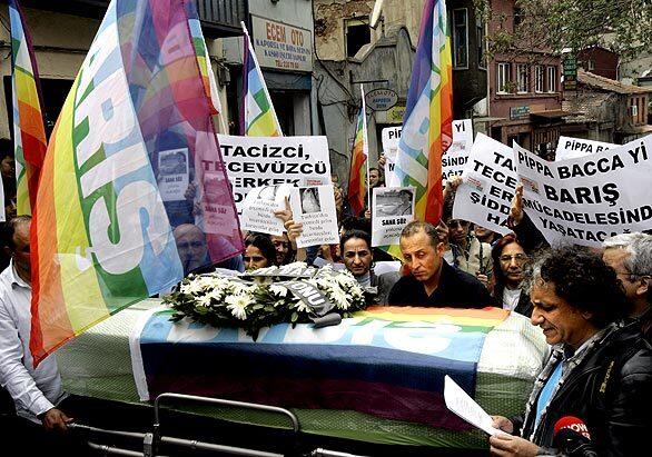 Turkish peace activists stand next to the coffin of Italian performance artist Giuseppina Pasqualino di Marineo, known as Pippa Bacca, during a ceremony in Istanbul, Turkey. She was raped and killed while hitchhiking in Turkey dressed in a wedding gown to appeal for peace in the Middle East. A Turkish man has been arrested in the case and, police say, confessed.