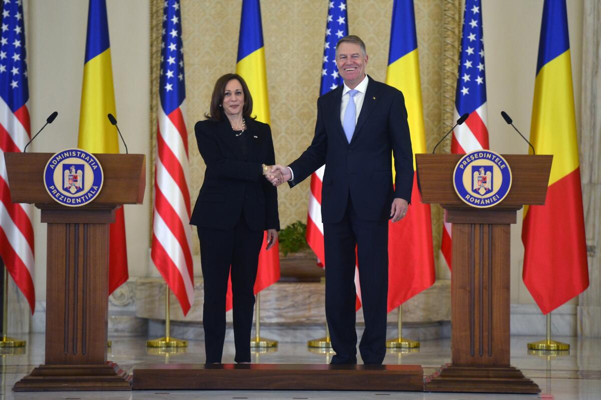 Vice President Kamala Harris shakes hands with Romanian President Klaus Iohannis
