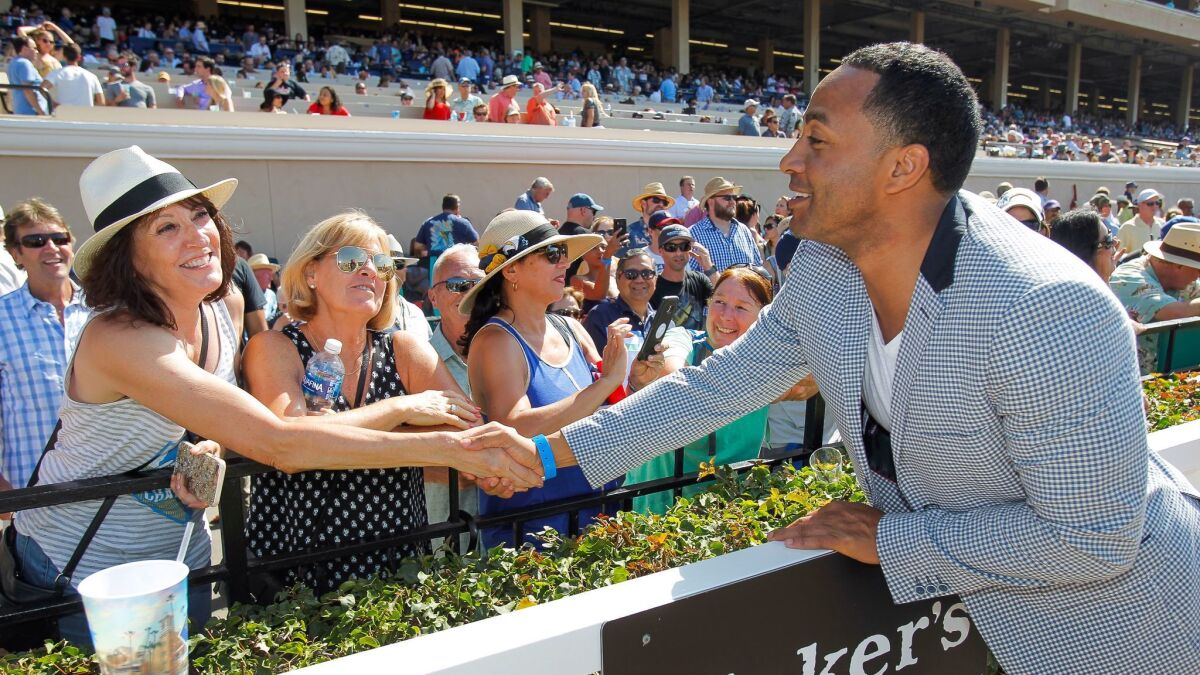 Former Chargers player Terrell Fletcher shakes hands with a fan at the Del Mar race track on Saturday.